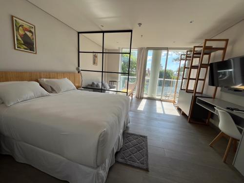 ein Schlafzimmer mit einem weißen Bett, einem Schreibtisch und einem Computer in der Unterkunft Solara Hotel Boutique in Asunción