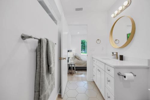 a white bathroom with a sink and a mirror at Ember & Oak - Modern Retreat Near Downtown - Pets in St. Augustine