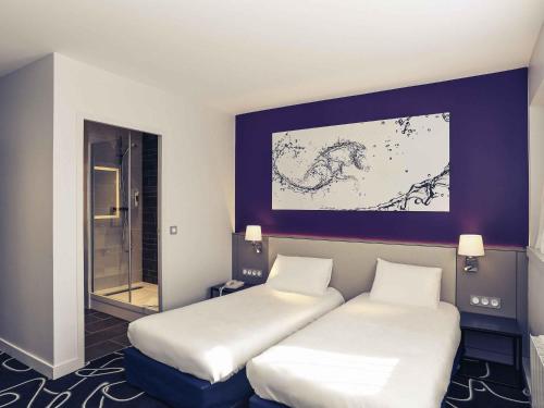 ein Zimmer mit zwei Betten und einem Gemälde an der Wand in der Unterkunft Mercure Saint Lô Centre in Saint Lo