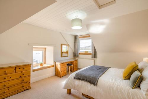 a bedroom with a bed and a dresser and a window at 3 Bed in Lochearnhead oc-c33641 in Lochearnhead
