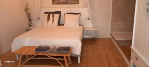 a bedroom with a bed with two pillows and a table at Lieu-dit Plaisance in Puygouzon-et-Montsalvy