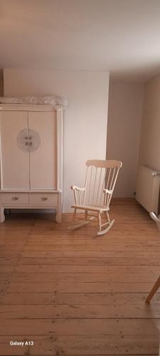 a room with a rocking chair and a dresser at Lieu-dit Plaisance in Puygouzon-et-Montsalvy