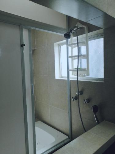 a shower with a glass door in a bathroom at La Casita Azul in Orizaba