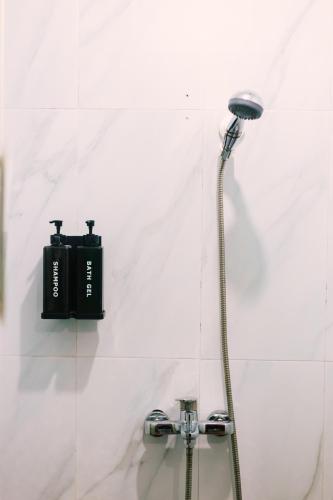 a shower in a bathroom with a black box on the wall at Ananas Guesthouse in Moalboal