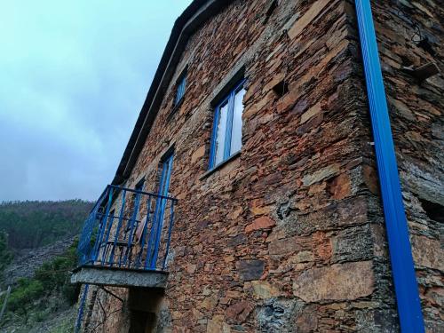 a brick building with a balcony on the side of it at Casa do Padrinho in Teixeira de Baixo