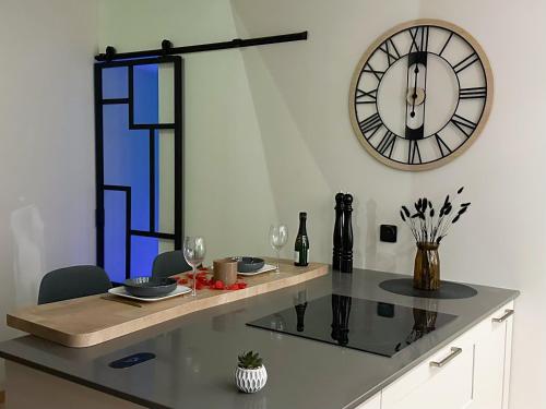 a dining table with a clock on the wall at L'Envol - Jacuzzi, Sauna et belle vue in Cherbourg en Cotentin