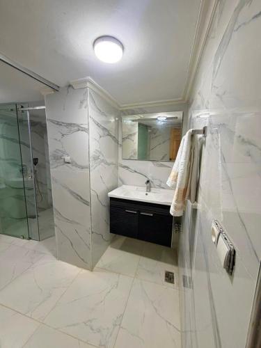 a white bathroom with a sink and a shower at Riad Fez Guests in Fez