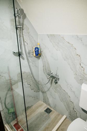 a shower in a bathroom with a marble wall at Mountain rest Brezna in Plužine