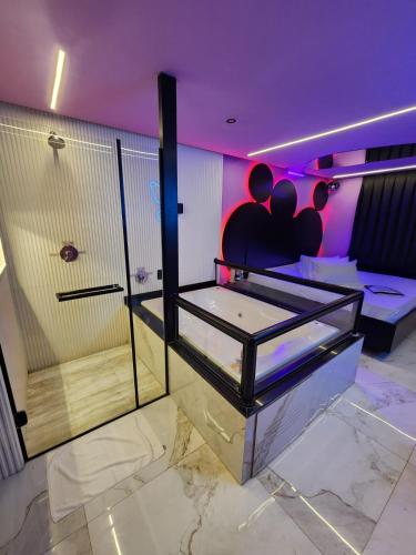 a room with a shower with two people on the wall at Fashion Motel in Limeira