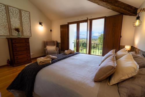 a bedroom with a large bed with a large window at El Caracol azul del Plano in Siero