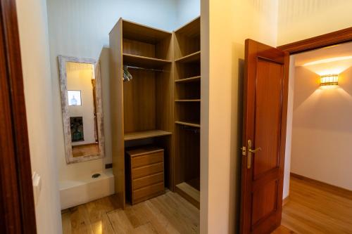 a walk in closet with a mirror and a door at El Caracol azul del Plano in Siero