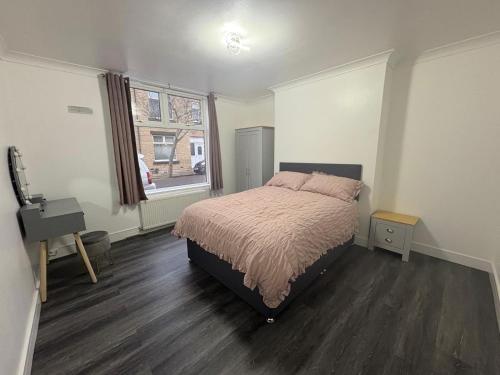 a bedroom with a bed and a desk and a window at 2 Bed Flat - Sleeps 3 - Parking - Wifi in West Boldon