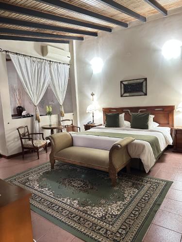 a bedroom with a large bed and a couch at Posada El Remanso de Pueblo Nuevo in San Cristóbal