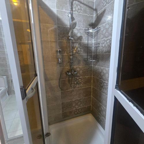 a shower with a glass door in a bathroom at Sweetland Vesidences in Yaoundé