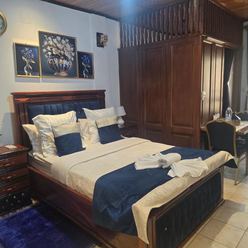 a bedroom with a large bed with blue and white sheets at Sweetland Vesidences in Yaoundé