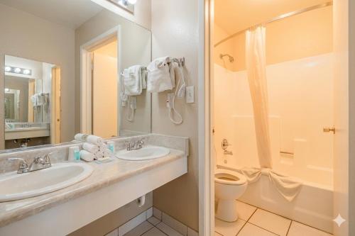 a bathroom with two sinks and a toilet and a shower at Super 8 by Wyndham Barstow in Barstow