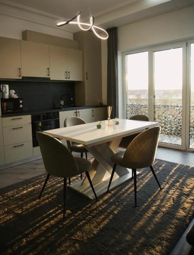a kitchen with a table and chairs in a room at Central Residence Sky Apartment in Rădăuţi