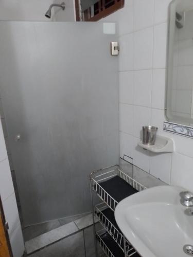 a white bathroom with a sink and a mirror at Elba Cabañas in Villa Carlos Paz