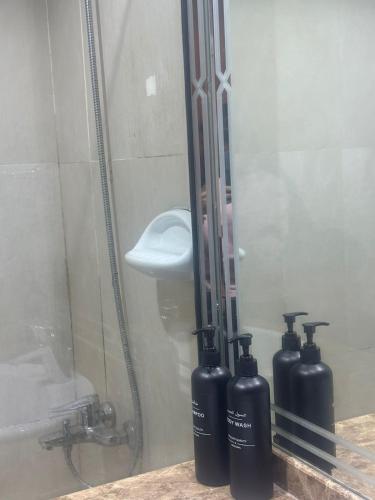 a shower with two oxygen bottles in front of a mirror at Abu Dhabi City Private Room Late Check out 2pm in Abu Dhabi