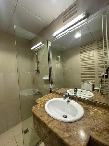 a bathroom with a sink and a shower at Abu Dhabi City Private Room Late Check out 2pm in Abu Dhabi