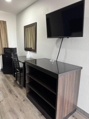 a room with a desk with a television on a wall at Economy Inn Fresno Yosemite '''NEWLY REMODELED''' in Fresno