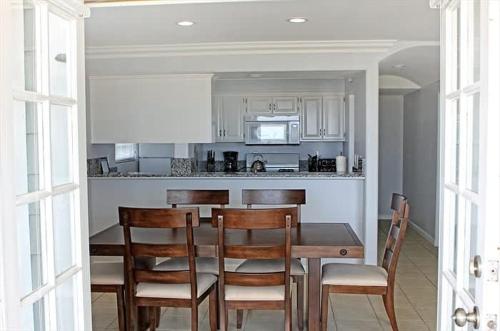 a kitchen with a table and chairs and a kitchen with a counter at 8-Bedroom Beachfront Triplex – Ideal for Extended apts in Newport Beach