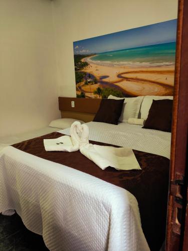a hotel room with two beds with towels on them at Hotel Trevo do Porto in Porto Seguro