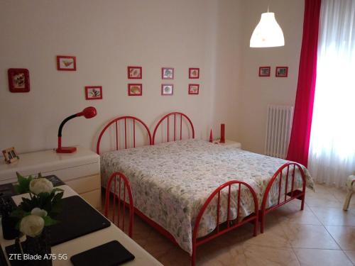 a bedroom with a bed and a table at Casa con veranda a 10 min dal mare in Lizzano