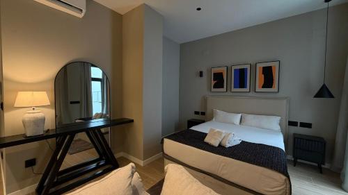 a bedroom with a bed and a mirror at Suites 43 Juan Llorens in Valencia