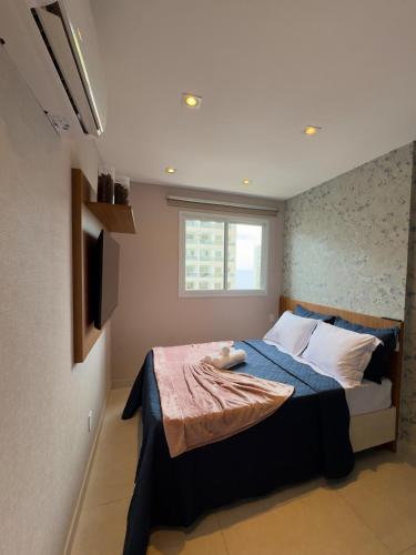 a bedroom with a bed and a television in it at Infinity 1302 - Piscina, Academia e Praia a Poucos Passos in Vila Velha