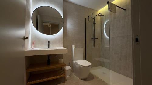 a bathroom with a toilet and a sink and a mirror at Suites 43 Juan Llorens in Valencia