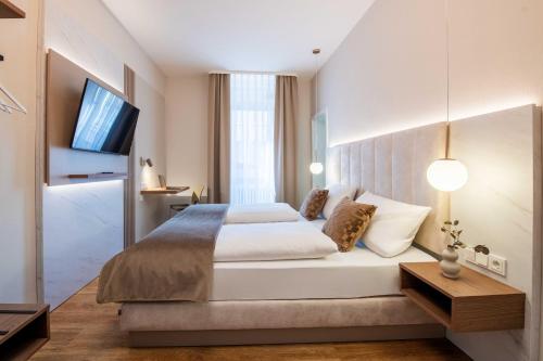 a bedroom with a large bed and a flat screen tv at Altstadt Hotel in Würzburg