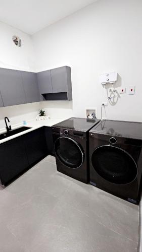 a kitchen with a sink and a washing machine at Villa Elegance-3 min Walk to the Beach-20 mins to Ochi Rios in Richmond