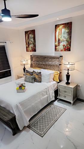 a bedroom with a large bed and a night stand at Villa Elegance-3 min Walk to the Beach-20 mins to Ochi Rios in Richmond