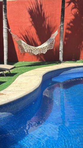 a hammock is hanging over a swimming pool at Casa Arcángel SM in Cruz de Huanacaxtle