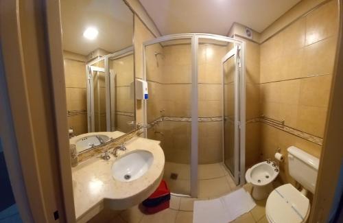 a bathroom with a sink and a shower and a toilet at Hotel Confianza in Corrientes