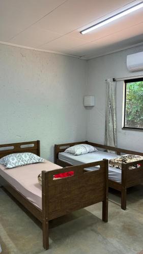 two beds sitting in a room with a window at Estância da Mata in CÃ¡ssia
