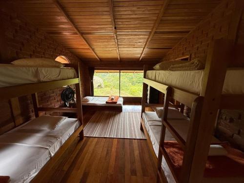 a room with three bunk beds and a window at Wisdom Forest Lodge in Tena