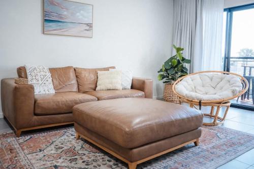 a living room with a couch and a chair at The Shell Shack on Whisper Bay in Cannonvale