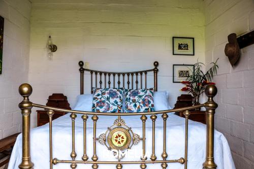 a bedroom with a bed with white sheets at Finca Romelia Orchids and Birds in Manizales