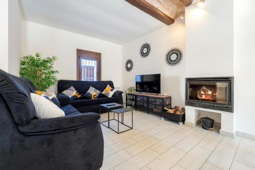 a living room with a couch and a fireplace at Hauzify I La Caseta in Santa Cristina d'Aro