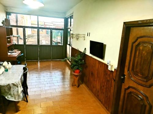 a living room with a table and a television and a door at Posada Familiar ELDORADO in Eldorado