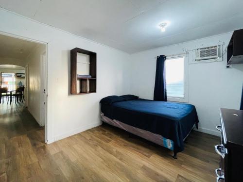 a bedroom with a bed and a window and a table at Windy days Apartments in Utila