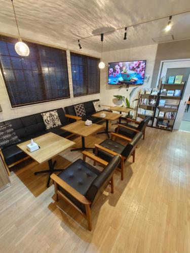 a restaurant with tables and chairs and a flat screen tv at 宿 inn TEK-TEK in Sanuki