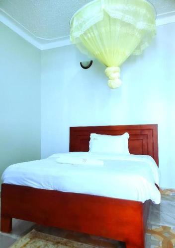 a bedroom with a bed with a light on the ceiling at Kanti Guest House, Arua in Arua
