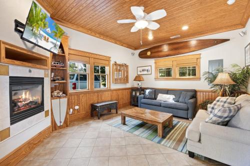 a living room with a couch and a fireplace at IC2 - Endless Summer Cottage in Manteo