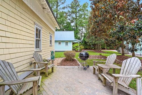 a patio with two chairs and a grill next to a house at IC2 - Endless Summer Cottage in Manteo