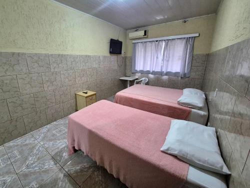 a hotel room with two beds and a window at Yves Hotel in Porto Velho