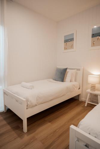 a white bed in a white room with a bed at Bay Days - Binalong Bay in Binalong Bay