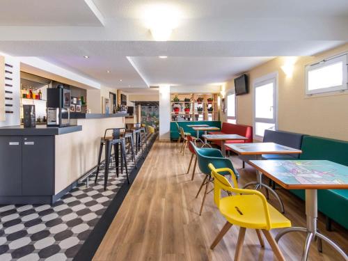 a restaurant with tables and chairs and a bar at ibis Rochefort in Rochefort